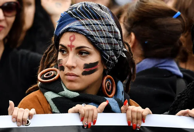 A woman with a Venus symbol for female painted on her forehead takes part in a demonstration to mark the International Day for the Elimination of Violence Against Women in Rome on November 25, 2017. (Photo by Tiziana Fabi/AFP Photo)