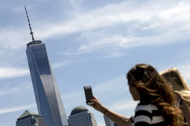 A woman uses her phone to photograph One World Trade Center tower in New York August 27, 2015. (Photo by Brendan McDermid/Reuters)