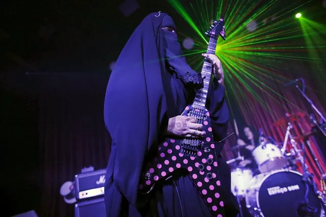 Gisele Marie, a Muslim woman and professional heavy metal musician, plays her Gibson Flying V electric guitar during a concert in Sao Paulo December 16, 2014. Based in Sao Paulo, Marie, 42, is the granddaughter of German Catholics, and converted to Islam several months after her father passed away in 2009. (Photo by Nacho Doce/Reuters)