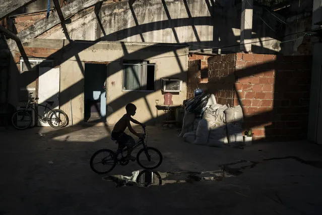 In this September 14, 2017 photo, a boy rides his bike inside the building that used to house the Brazilian Institute of Geography and Statistics (IBGE), occupied by hundreds of people in the Mangueira slum of Rio de Janeiro, Brazil. The trend of Brazilians emerging from poverty has been reversed over the last two years due to the deepest recession in Brazil’s history and cuts to the subsidy programs. (Photo by Felipe Dana/AP Photo)