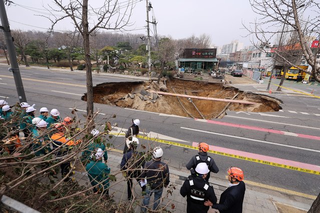 Emergency workers stand near a sinkhole in a road, in Seoul, South Korea, on March 25, 2025. (Photo by Yonhap via Reuters)