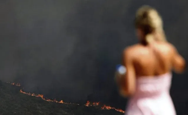 A woman looks at the flames raging across burning land at the Natural Park La Granadella in Benitatxell, at the Costa Blanca in Valencia, Spain, on 05 September 2016. The fire, declared the previous day, has reached Xabia municipality forcing hundreds of evacuations. (Photo by EPA/Morell)