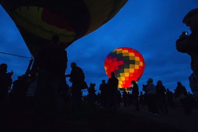 Attendees walk by a hot air balloon lit up by flames as it prepares for take off during the 2015 Albuquerque International Balloon Fiesta in Albuquerque, New Mexico, October 4, 2015. (Photo by Lucas Jackson/Reuters)