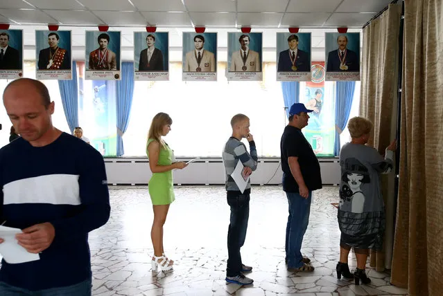 People wait in a queue in front of a voting booth during a parliamentary election at a polling station in Minsk, Belarus September 11, 2016. (Photo by Vasily Fedosenko/Reuters)