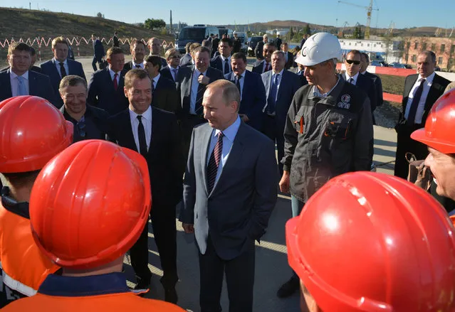 Russian President Vladimir Putin (C), Prime Minister Dmitry Medvedev (front 2nd L) and businessman Arkady Rotenberg (front L) meet with employees as they visit the site of the construction of a bridge across the Kerch Strait in Kerch, Crimea, September 15, 2016. (Photo by Alexei Druzhinin/Reuters/Sputnik/Kremlin)