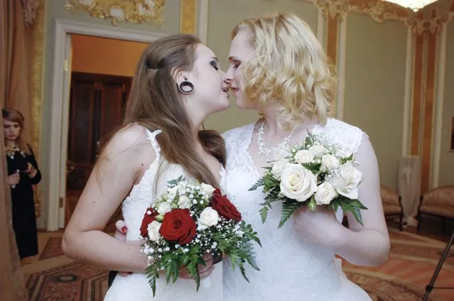 Two brides kiss during their wedding ceremony to each other at the wedding registry office in St. Petersburg November 7, 2014. The two St. Petersburg women married in the official city ceremony last week, seemingly circumventing Russia's ban on same-s*x marriages. Petersburg lawmaker has vowed to nullify their wedding. (Photo by Reuters/Stringer)
