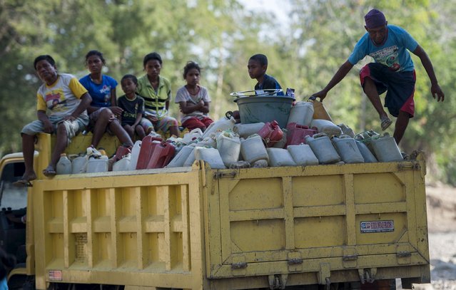 Residents ride on a truck carrying jerry cans filled with water collected from a water source in the Sanleo village in Malaka district, Indonesia Nusa Tenggara Timur province, October 10, 2015 in this pictures taken by Antara Foto. Residents travel as far as three kilometers (1.8 miles) from their village to collect water during the long drought season, Antara said. (Photo by Prasetyo Utomo/Reuters/Antara Foto)