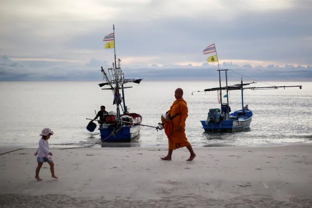 A Buddhist monk and a child walk on a beach in Hua Hin, Thailand September 19, 2016. (Photo by Jorge Silva/Reuters)