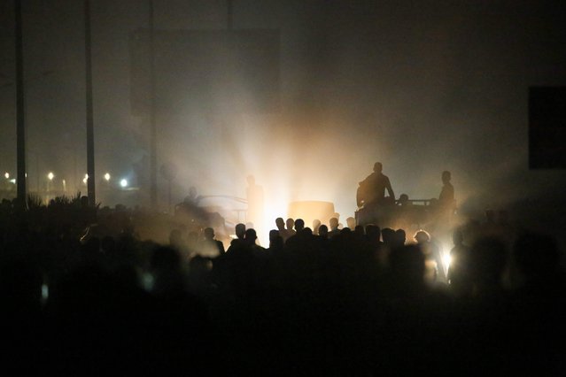 Palestinians gather as trucks carrying humanitarian aid arrive at a distribution point in the Bureij camp for Palestinian refugees in the central Gaza Strip early on June 9, 2025. (Photo by Eyad Baba/AFP Photo)