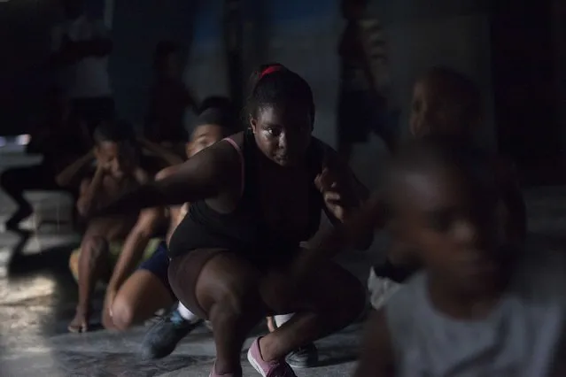 Children exercise during a wrestling lesson in downtown Havana, October 20, 2014. (Photo by Alexandre Meneghini/Reuters)