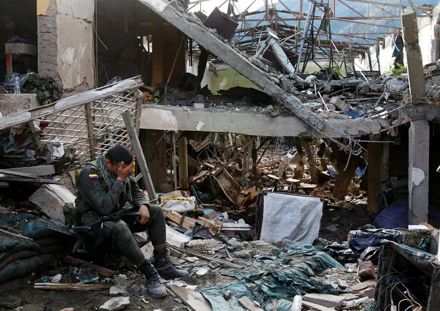 A police officer reacts amid the ruins of a police station which was destroyed by a bomb attack in the municipality of Inza in Cauca province December 7, 2013. (Photo by Jaime Saldarriaga/Reuters)