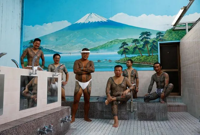 Tattoo artist Asakusa Horikazu poses for a photograph with people who received tattoos from Horikazu and his father, at a Japanese public bath called a “sento” in Tokyo, Japan, September 24, 2020. “It's been a problem at places like super sento and spas. I think it's because there's a strong image that they're against society. I take steps to make sure nothing that shouldn't be shown isn't, and I go into pools and things” " said Horikazu. (Photo by Kim Kyung-Hoon/Reuters)