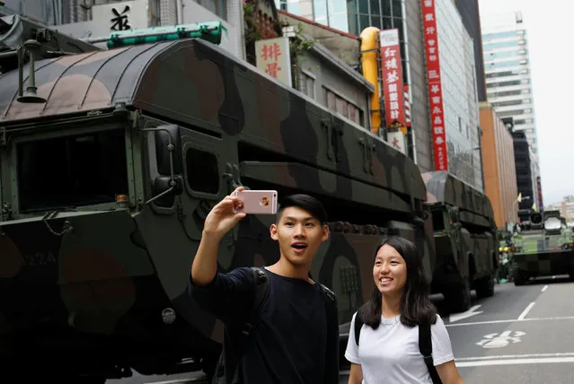 People take a selfie in front of military vehicles during a rehearsal two days before Taiwan's National Day on October 10 to mark the founding of the Republic of China on 1911, in Taipei, Taiwan October 8, 2016. (Photo by Tyrone Siu/Reuters)