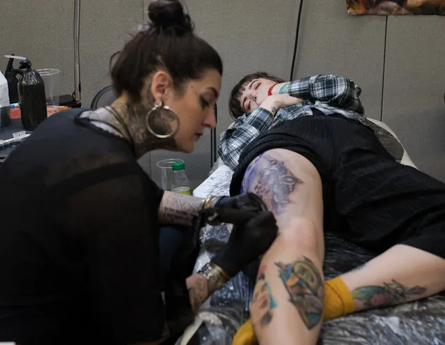 A tattoo artist at work at the Tattoo Collective convention, which features 150 tattoo artists, at the Old Truman Brewery in east London, England on March 18, 2018. (Photo by Alecsandra Raluca Dragoi/The Guardian)