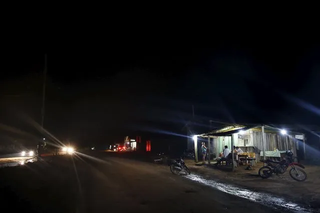 Residents talk in a restaurant at night in the village of Rio Pardo next to Bom Futuro National Forest, in the district of Porto Velho, Rondonia State, Brazil, August 31, 2015. (Photo by Nacho Doce/Reuters)