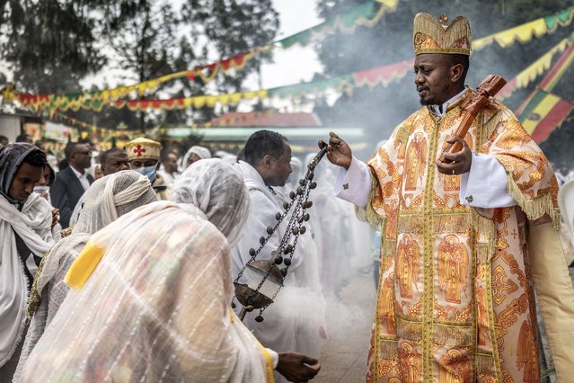 An Ethiopian Orthodox priest swings a censer as faithful sing religious songs and prayers during a New Year church celebration at Entoto St. Raguel Church in Addis Ababa, on September 11, 2025. Ethiopia marks the New Year, Enkutatash in Amharic, on September 11, celebrating the end of the rainy season and the start of the Ethiopian calendar year 2018, which runs about seven to eight years behind the Gregorian calendar. (Photo by Luis Tato/AFP Photo)