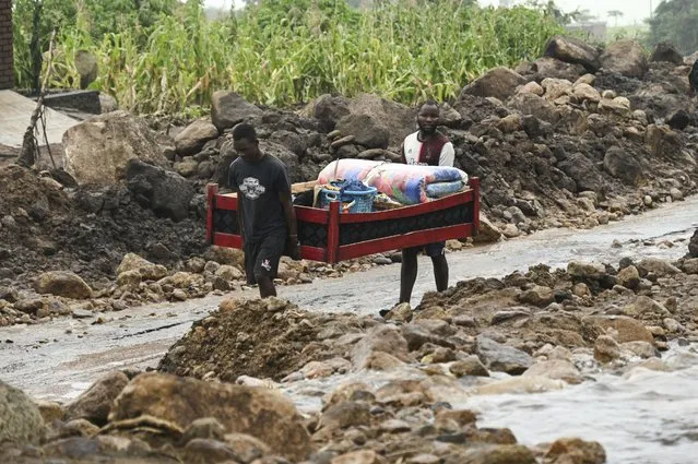 Men transport their salvaged belongings in Chiradzulu, southern Malawi, Friday March 17, 2023. Authorities are still getting to grips with the scale of Cyclone Freddy's destruction in Malawi and Mozambique since late Saturday, with over 300 people confirmed dead and several hundreds still displaced or missing. (Photo by Thoko Chikondi/AP Photo)