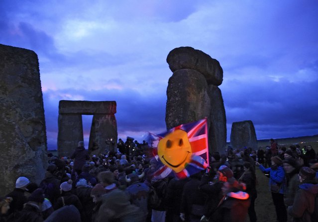 Revellers celebrate as the sun rises during the winter solstice at Stonehenge on Salisbury plain in southern England December 22, 2014. (Photo by Dylan Martinez/Reuters)