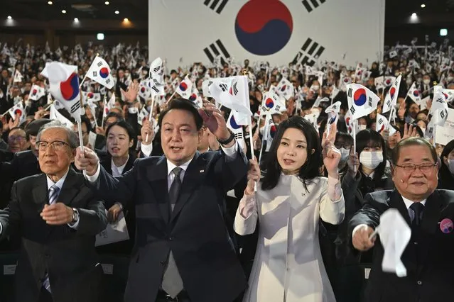 South Korea's President Yoon Suk Yeol, center left, and his wife Kim Keon Hee, center right, give three cheers during a ceremony of the 104th anniversary of the March 1st Independence Movement Day against Japanese colonial rule, in Seoul Wednesday, March 1, 2023. (Photo by Jung Yeon-je/Pool Photo via AP Photo)