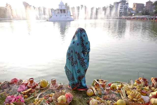A Nepalese Hindu devotee prays to the setting sun while standing at the Ranipokhari pond during the Chhath festival in Kathmandu, Nepal, 17 November 2015. The Chhath festival is observed by Hindus men and women for a prosperous life of their wives, husbands and family members. It is dedicated to Lords Surya (Sun) and Agni (fire). Devotees fast, bath, and stand in the water for long periods of time offering prayers to the setting and rising sun. (Photo by Narendra Shrestha/EPA)