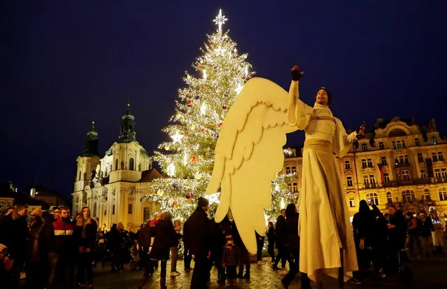 A man dressed as an angel walks across the Old Town Square amid the coronavirus disease (COVID-19) outbreak in Prague, Czech Republic, December 20, 2020. (Photo by David W. Cerny/Reuters)