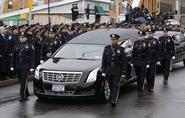 A hearse carrying the casket containing New York Police Department officer Wenjian Liu makes its way in a procession down 65th Street following his funeral service in the Brooklyn borough of New York January 4, 2015. (Photo by Mike Segar/Reuters)
