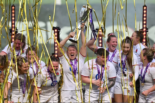 England's teammates celebrate with the trophy after winning the Women's Six Nations Grand Slam at the end of the Six Nations international women's rugby union match between England and France at Twickenham in south-west London on April 29, 2023. England won 38 - 33 against France. (Photo by Glyn Kirk/AFP Photo)