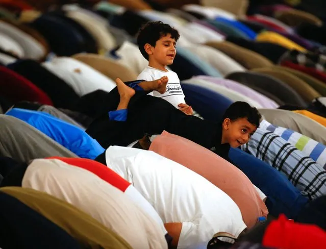 Children play over their parents as they take part in evening prayers called “Tarawih” on Laylat al-Qadr or Night of Decree, at Amr Ibn El-Aas mosque, the first and oldest mosque ever built on the land of Egypt, during the Muslim holy month of Ramadan, in old Cairo, Egypt on April 17, 2023. (Photo by Amr Abdallah Dalsh/Reuters)