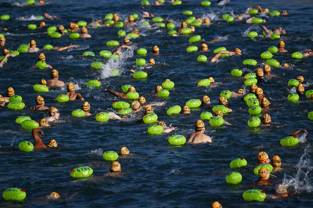 Participants take part in the Harbour Race, where swimmers cross Hong Kong's Victoria Harbour, in the city on November 22, 2025. (Photo by Peter Parks/AFP Photo)