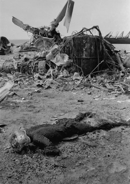 A charred body with helmet lies beside wreckage of a helicopter, April 27, 1980, in the desert area of eastern Iran, Dasht-E-Kavir. Five bodies have been recovered from the wreckage of American aircraft in the desert following the American forces attempted rescue of the 50 U.S. hostages being held in the U.S. Embassy in Teheran. (Photo by Mohammad Sayyad/AP Photo)