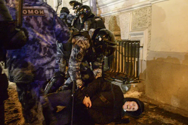 Police officers detain a Navalny supporter at the Red Square in Moscow, Russia, Tuesday, February 2, 2021. A Moscow court has ordered Russian opposition leader Alexei Navalny to prison for more than 2 1/2 years on charges that he violated the terms of his probation while he was recuperating in Germany from nerve-agent poisoning. Navalny, who is the most prominent critic of President Vladimir Putin, had earlier denounced the proceedings as a vain attempt by the Kremlin to scare millions of Russians into submission. (Photo by Denis Kaminev/AP Photo)