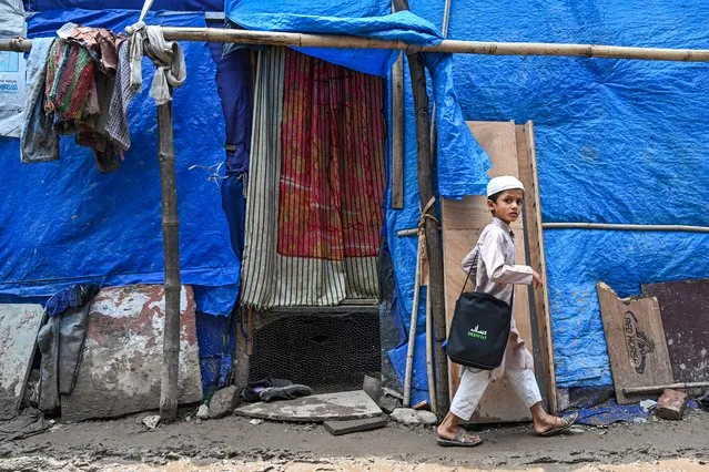 A Rohingya refugee boy walks along a street at a refugee camp on the World Refugee Day, in New Delhi on June 20, 2023. (Photo by Arun Sankar/AFP Photo)
