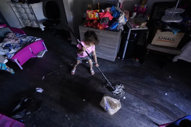 Raella Mills, 3, plays mop-up at her home Tuesday, February 23, 2021, in Dallas. Raella and her mother's apartment flooded last week by a pipe that burst during the record winter cold. They are still without running water. (Photo by L.M. Otero/AP Photo)
