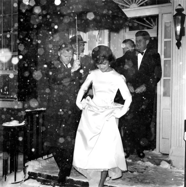 Jacqueline Kennedy lifts the skirt of her inaugural ball gown as she and her husband, President-elect John F. Kennedy, leave their Georgetown home in the snowfall en route to the inaugural concert in Washington, D.C., January 19, 1961. (Photo by AP Photo)