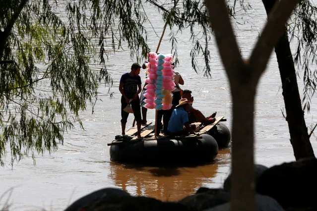 A man selling cotton candy crosses the Suchiate river, a natural border between Mexico and Guatemala, on a raft in Ciudad Hidalgo, Chiapas, Mexico November 16, 2016. (Photo by Carlos Jasso/Reuters)
