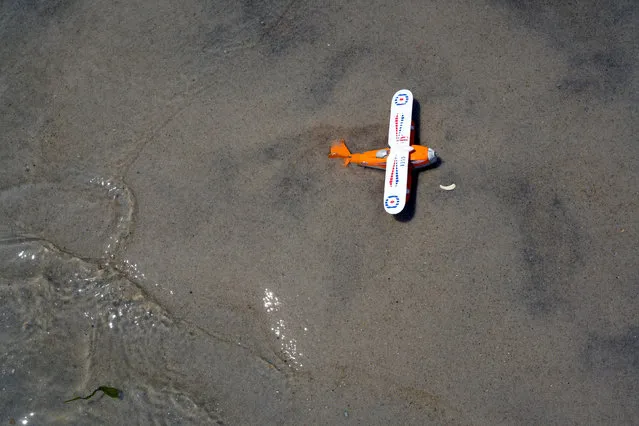 A toy plane sits in the sand during a Memorial Day event at Jones Beach on Long Island, New York, U.S., May 26, 2018. (Photo by Johnny Milano/Reuters)