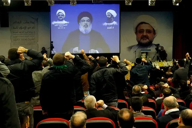Lebanon's Hezbollah leader Sayyed Hassan Nasrallah addresses his supporters via a screen during a memorial service to mourn the death of Sheikh Mohammad Khatoun who was a member of Hezbollah Central Council, and to condemn the execution of Sheikh Nimr al-Nimr, a Shi'ite cleric who was executed along with others in Saudi Arabia, in Beirut's southern suburbs January 3, 2016. Nasrallah said on Sunday Saudi Arabia's execution of Shi'ite cleric Nimr was a "message of blood", and Riyadh sought to create sectarian strife across the world. (Photo by Issam Kobeisi/Reuters)