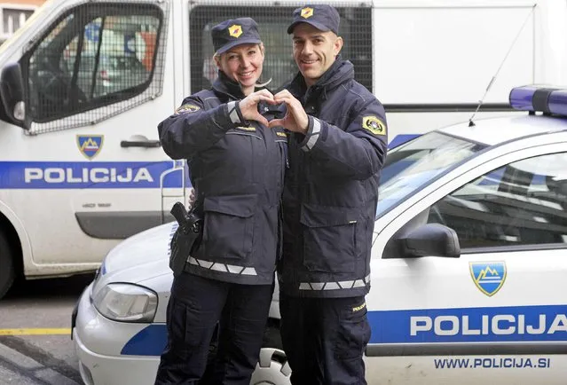 Police officers Tomaz and Andreja Fabjan Podobnik make a heart-shaped gesture in police station in Ljubljana, Slovenia February 10, 2015. They have been living together for 7 years and work at the same police station. Valentine's Day is observed annually by couples around the world on February 14. (Photo by Srdjan Zivulovic/Reuters)