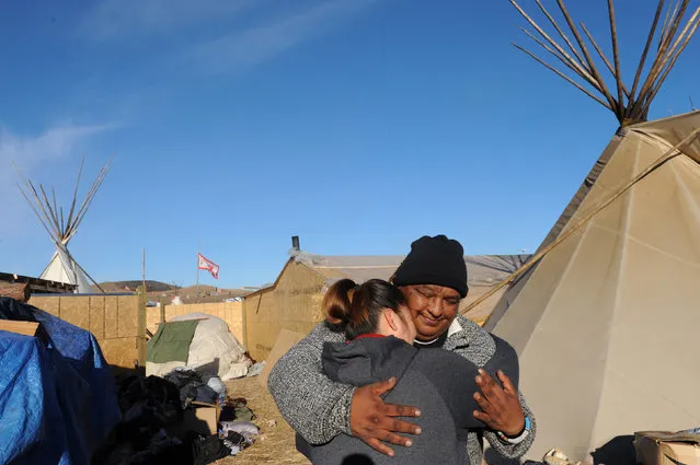 Two people share a hug in the Oceti Sakowin camp during a protest against plans to pass the Dakota Access pipeline near the Standing Rock Indian Reservation, near Cannon Ball, North Dakota, U.S. November 26, 2016. (Photo by Stephanie Keith/Reuters)
