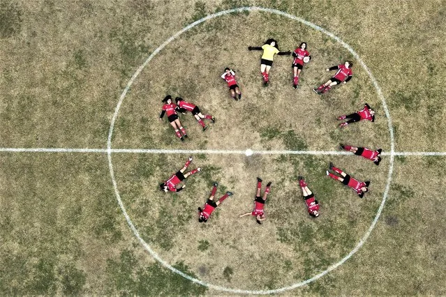Candelaria Cabrera, top right, holds a ball as she and her soccer team Huracán de Chabas female pose for photos on the field prior to their match against Alumni in Arequito, Santa Fe province, Argentina, Monday, June 19, 2023. Candelaria's struggle to keep playing was a turning point in Argentina's women's soccer. (Photo by Natacha Pisarenko/AP Photo)