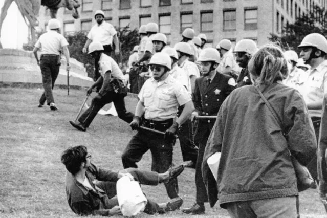 In this August 26, 1968 file photo, Chicago police officers wielding nightsticks confront a demonstrator on the ground in Grant Park after protesters against the Vietnam War climbed on the statue of Civil War Gen. John Logan. It was one of many protests during the tumultuous 1968 Democratic National Convention. (Photo by AP Photo)