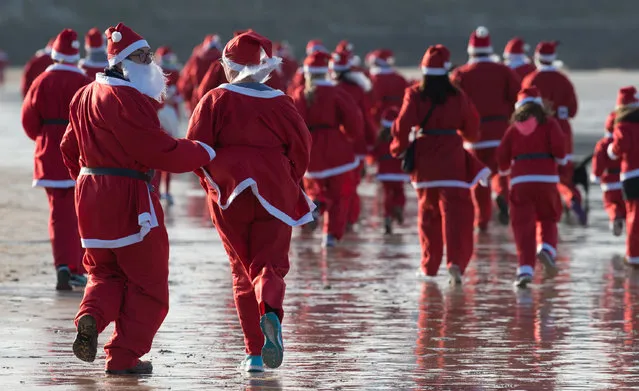 People dressed as Santa take part in the beach fun run as part of the Santa Run and Surf 2016 at Fistral Beach in Newquay on December 4, 2016 in Cornwall, England. (Photo by Matt Cardy/Getty Images)
