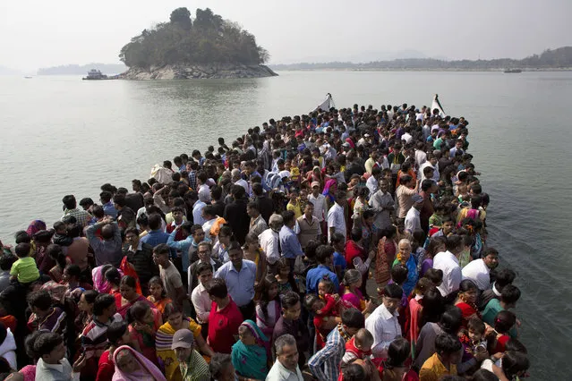 Indian devotees travel on a ferry to Umananda, left, a river island in the Brahmaputra that houses a Shiva temple, during Shivratri festival in Gauhati, India, Tuesday, February 17, 2015. Shivratri, or the night of Shiva, is dedicated to the worship of Lord Shiva, the Hindu god of destruction. (Photo by Anupam Nath/AP Photo)