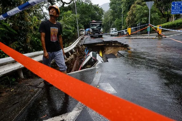 A vehicle is seen at a collapsed road section after flood and heavy rains, in Hong Kong, China on September 8, 2023. (Photo by Tyrone Siu/Reuters)