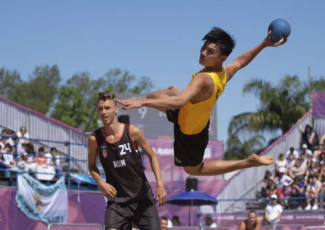Thailand’s Surasak Waenwiset tries a shot as Hungary’s Marcell Fenyvesi stands nearby, during their Beach Handball Men’s Tournament match in Tecnopolis Park, during the Youth Olympic Summer Games in Buenos Aires, Argentina on October 9, 2018. (Photo by Florian Eisele/AP Photo)