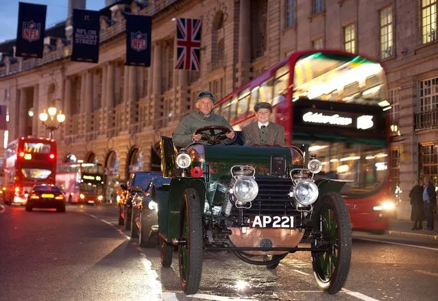 A 1903 Daimler, driven by Ben Cussons with his son Alex beside him, leads an  Aston Martin Vanquish and a Renault ZOE along London's Regent Street on October 22, 2013, to launch the Regent Street Motor Show traffic-free event, which will take place on Saturday November 2. (Photo by David Parry/PA Wire)