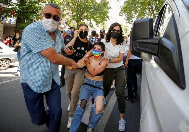 A demonstrator is detained by plain-clothes police officers as she tries to attend a Pride parade, which was banned by local authorities, in central Ankara, Turkey on June 29, 2021. (Photo by Cagla Gurdogan/Reuters)
