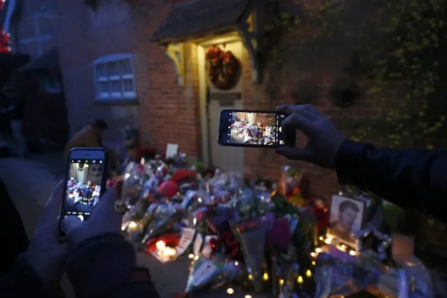 Smartphone screens are lit up as people photograph candlelit tributes outside the house of singer George Michael, where he died on Christmas Day, in Goring, southern England, Britain December 26, 2016. (Photo by Eddie Keogh/Reuters)