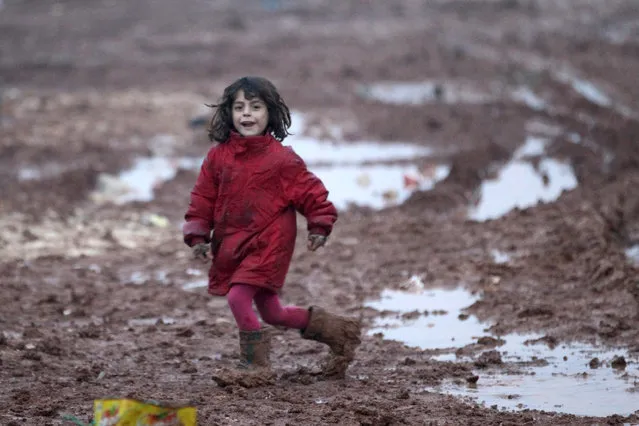 An internally displaced Syrian girl runs through mud in the Bab Al-Salam refugee camp, near the Syrian-Turkish border, northern Aleppo province, Syria December 26, 2016. (Photo by Khalid al Mousily/Reuters)