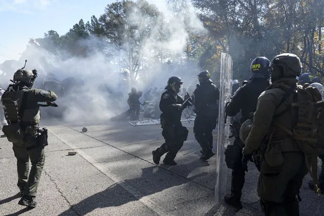 Police disperse a crowd of protesters with gas during a demonstration in opposition to a new police training center, Monday, November 13, 2023, in Atlanta. (Photo by Mike Stewart/AP Photo)